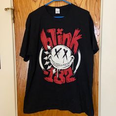 a black t - shirt with the words punk on it hanging from a wooden door