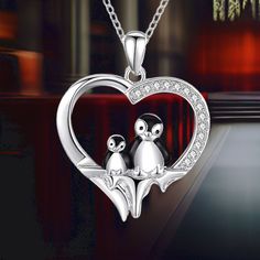 Introducing our heartwarming Penguin Necklace, a symbol of love, friendship, and the eternal bond between a mother and her baby. This pendant design beautifully captures the essence of family, showcasing the enduring love and connection between these two adorable penguins. Crafted from 925 sterling silver, our penguin necklace is not only visually appealing but also anti-allergic, anti-tarnishing, nickel-free, cadmium-free, and lead-free. It's designed for long-term wear, ensuring your comfort a Silver Heart Necklace With Clavicle Chain For Mom, White Gold Necklace For Mother's Day, Sterling Silver Heart Pendant Necklace Gift, Silver Double Heart Necklaces For Gifts, Silver Double Heart Necklaces As Gifts, Silver Double Heart Necklace As Gift, Silver Heart Pendant Necklace As Gift, Adorable Penguins, Penguin Necklace