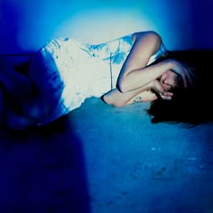 a woman is laying on the floor with her head down and hands behind her back