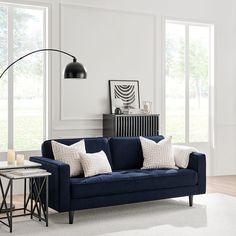 a living room scene with focus on the blue couch and white carpeted flooring