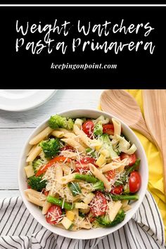 a white bowl filled with pasta and veggies on top of a wooden table