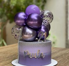 a cake with purple and silver balloons on it that says paula in the center