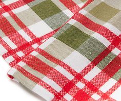 a red and green checkered table cloth on a white surface with clippings