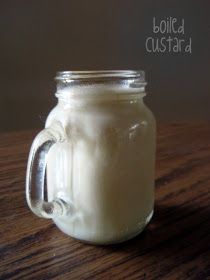 a glass jar filled with white liquid sitting on top of a wooden table