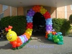 an entrance to a party with balloons in the shape of caterpillars and flowers