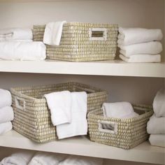 towels are stacked in baskets on the shelves