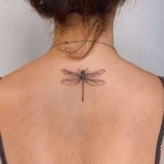 a woman with a dragonfly tattoo on her back