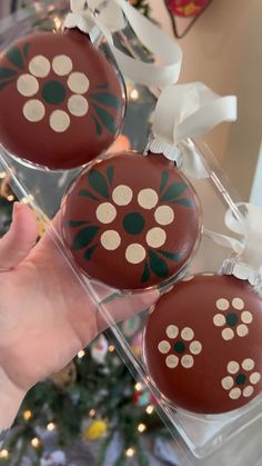 two decorated chocolates sitting in front of a christmas tree