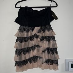 a dress hanging on a clothes hanger next to a wall with a phone plugged in