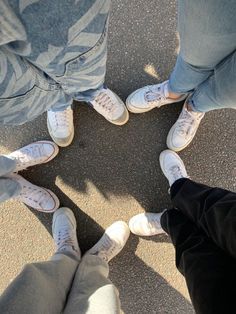 four people standing in a circle with their feet on the ground