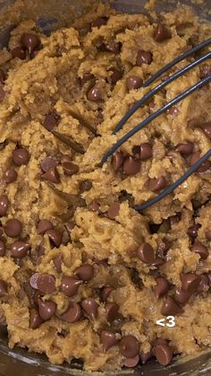 chocolate chip cookie batter in a bowl with a whisk on the side and an oatmeal