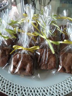 chocolate brownies wrapped in cellophane and tied with yellow ribbon on a white plate