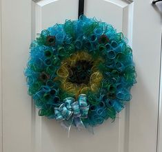 a blue and green wreath hanging on the front door