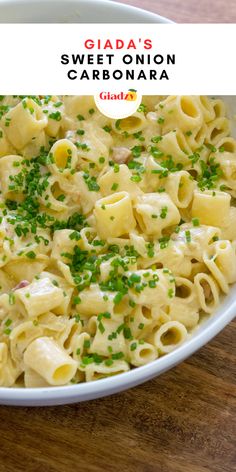 a white bowl filled with macaroni and cheese on top of a wooden table