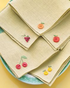 three napkins are stacked on top of each other with buttons attached to them,