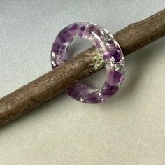 an amethorate ring sitting on top of a stick next to a piece of wood