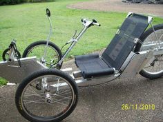 an old fashioned tricycle is parked on the side of the road in front of some grass