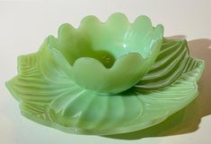 a green flower shaped bowl sitting on top of a table