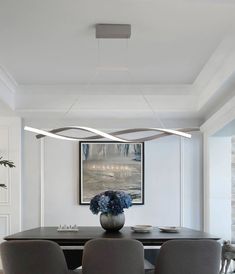 a dining room table with chairs and a vase on top of the table in front of it