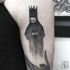 a person with a bird on their arm and a skull in the middle of it