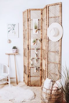 a room with a white chair and a large wooden screen in the corner that has plants on it