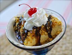 an ice cream sundae in a glass bowl with a cherry on top and chocolate sauce drizzled over it