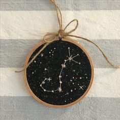 a wooden ornament with the zodiac sign on it is hanging from a string