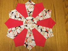 a red and white christmas ornament sitting on top of a wooden table