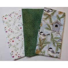 three different fabric samples with birds and flowers on them, one in green, the other in white