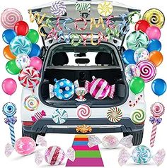 the trunk of a car is filled with candy and lollipops