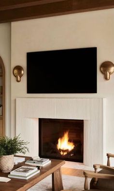 a living room filled with furniture and a flat screen tv mounted above the fire place