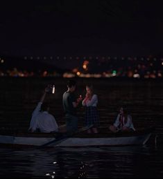 some people are sitting in a small boat at night