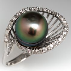 This striking ring is centered with one (1), post set, cultured Tahitian pearl. The pear is bordered with twenty-six (26), bead set, round brilliant cut diamonds. The ring measures 17.8mm at the top, rises 13.8mm above the finger, tapering to 2.7mm wide and 1.1mm thick at the base of the shank. This ring is currently a size 6.5. Tahitian Pearl Ring With Diamond Accents For Wedding, Classic Tahitian Pearl Ring With Diamond Accents, Tahitian Pearl Ring With Diamond Accents Fine Jewelry, Fine Jewelry Tahitian Pearl Ring With Diamond Accents, Tahitian Pearl Rings With Diamond Accents For Anniversary, Tahitian Pearl Ring With Diamond Accents, Classic Tahitian Pearl Ring For Anniversary, Elegant Tahitian Pearl Ring With Diamond Accents, Classic Tahitian Pearl Ring For Formal Occasions