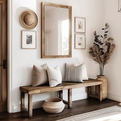 a wooden bench sitting under a large mirror