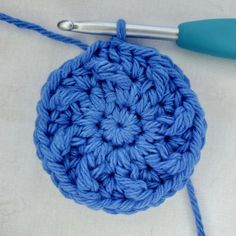 a crochet ball with yarn next to it and a knitting needle on the side