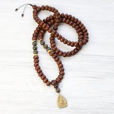 Inspired by our best-selling and customer favorite Energizing Bodhi Seed Wrist Mala! The set includes both the mala necklace and bracelet version of the exclusive style. Hand strung here at the DharmaShop with high quality Bodhi Seeds, gorgeous Labradorite gemstones, and Gold Vermeil accents. Completed with a brass Thai Buddha protection amulet handcrafted by monks in Thailand to help support their Wats (temples). These amulets are believed to be "good luck charms." Bodhi Seed beads can be used Hand Knotted Traditional Jewelry For Gifts, Traditional Hand Knotted Jewelry As Gift, Traditional Hand Knotted Jewelry For Gifts, Traditional Hand-knotted Jewelry Gift, Gold Hand-strung Mala For Meditation, Good Luck Charms, Thai Buddha, Wrist Mala, Adjustable Knot