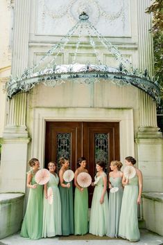 a group of women standing next to each other in front of a building