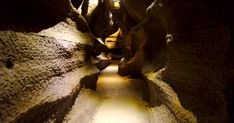 an image of a narrow tunnel with light coming in from the top and some rocks on either side