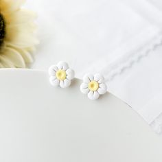 Elevate your accessory game with our cute white daisy earrings studs, perfect for any occasion. Crafted from lightweight polymer clay, these stunning earrings embody the essence of cottagecore style, making them the ideal boho earrings for women who adore floral designs. Designed with sensitive ears in mind, our hypoallergenic studs feature a durable stainless steel post that ensures comfort for everyone. These trendy artisan-made jewelry pieces make unique gifts for teenage girls or anyone look White Daisy Earrings Unique, Clip On Earrings For Teens, Cottagecore Earrings, Gifts Boho, Earrings Clay, Cottagecore Style, Daisy Earrings, White Daisy