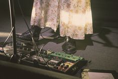 a person standing in front of a microphone and electronic equipment on the ground next to a pair of shoes