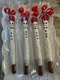 four snowman pretzels wrapped in cellophane