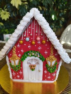 a gingerbread house with decorations on the outside and inside is decorated in gold, white, and red