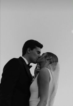 a bride and groom kissing in black and white