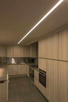 an empty kitchen with wooden cabinets and stainless steel appliances