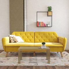 a living room with a yellow couch, coffee table and bookshelf on the wall