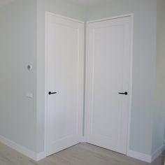 an empty room with two white doors in it