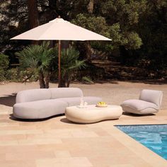 an outdoor lounge set next to a swimming pool