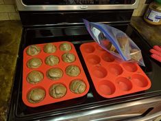 two trays of cookies sitting on top of an oven next to some baking utensils