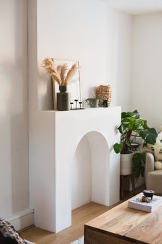 a living room filled with furniture and a fire place in front of a white wall