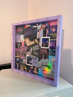 a bed topped with a purple frame covered in pictures